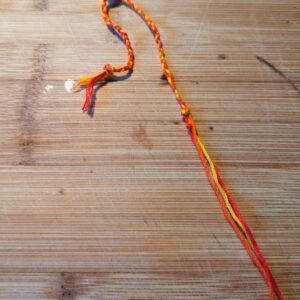 Woven Thread Bracelet in Red, Orange & Yellow with Bead Accent